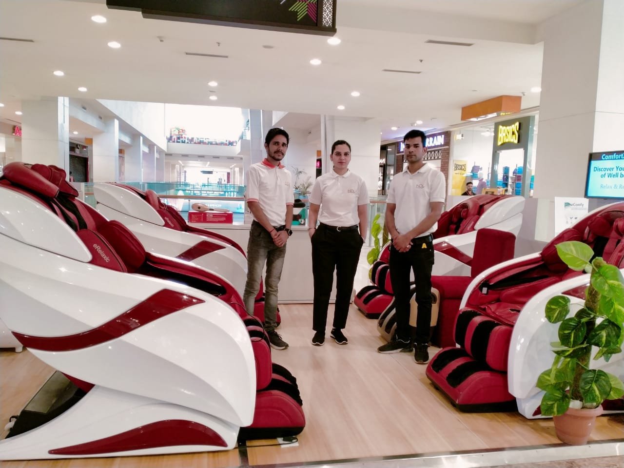 a group of people standing in a room with massage chairs